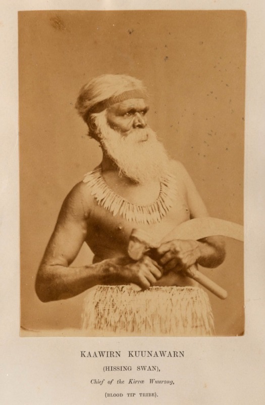 An albumen paper portrait photograph laid down on a title page from the book "Australian Aborigines" by James Dawson, 1881; the striking image depicts "KAAWIRN KUUNAWARN" (Hissing Swan), Chief of the Kirrae Wuurong people of the Mortlake District in Gipps