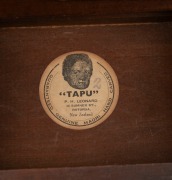 Two carved New Zealand boxes decorated with carved Tiki with paua shell eyes and with pictorial labels "Tapu: P. H. Leonard, 26 Sumner St, Rotorua, New Zealand. Guaranteed Genuine Maori Hand Carved",&nbsp; 4.5cm high, 13.5cm wide, 10cm deep - 3