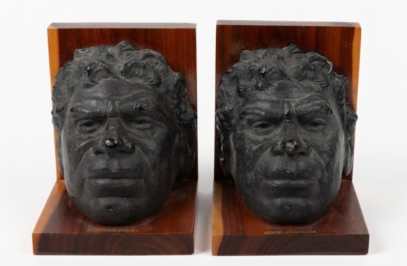 ALBERT NAMATJIRA pair of fired plaster and mulga wood bookends, mid 20th century, stamped to bases "MULGA WOOD" with Crown Mulga trademark, ​​​​​​​15cm high