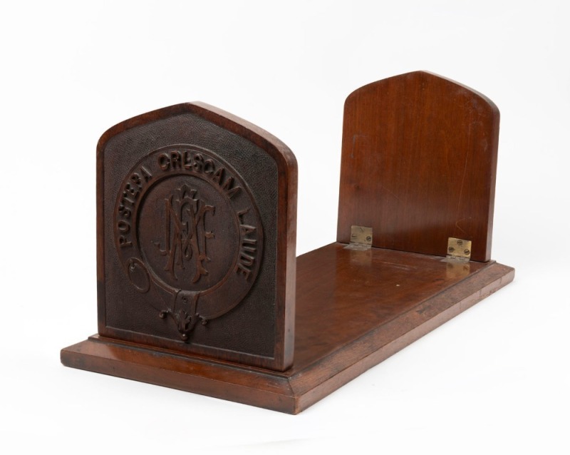 THE UNIVERSITY OF MELBOURNE antique Australian arts & crafts carved walnut bookstand with angel and Southern Cross surrounded by the university's motto and monogram, 19th/20th century, 22cm high, 51cm wide