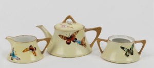 JESSIE MOORE (South Australia) hand-painted three piece tea service with blossom and butterfly decoration, signed "Jessie Moore, 1912", the teapot 11cm high, 19cm wide