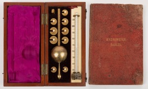 T. F. WIESENER of SYDNEY: Mahogany and boxwood strung cased hydrometer set with measures and ivory scaled mercury thermometer, maker's ivorine label to the lid; together with a book titled "Hydrometer Tables", 19th century, (2 items), the case 6cm high, 20cm wide, 10cm deep