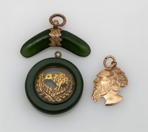 An antique New Zealand greenstone boomerang charm mounted in 9ct gold; together with a New Zealand greenstone and yellow gold kiwi and fern charm and a 9ct gold charm of an Aboriginal man's head, (3 items), the boomerang 2.5cm wide