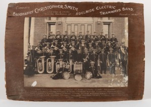 ADELAIDE ELECTRIC TRAMWAYS BAND. Large format antique black and white albumen photograph with remains of timber mount with caption "Presented To Bandmaster CHRISTOPHER SMITH, ADELAIDE ELECTRIC TRAMWAYS BAND, 1914", and further captioned with names of the members. Rustic barn find relic condition. 54 x 77cm overall