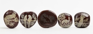 Four Australian folk art burra nut ornaments hand-painted with native parrots, cockatoo, palm cockatoo and emu; together with a carved kangaroo example, Queensland origin, 19th/20th century, (5 items), the largest 5.3cm wide