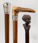 GEORGE ADAMS - TATTERSALLS: antique walking stick with carved antler handle, silver collar engraved with ownership details, timber shaft and metal ferrule; together with an African timber walking stick with carved head handle and specimen wood segmented - 2
