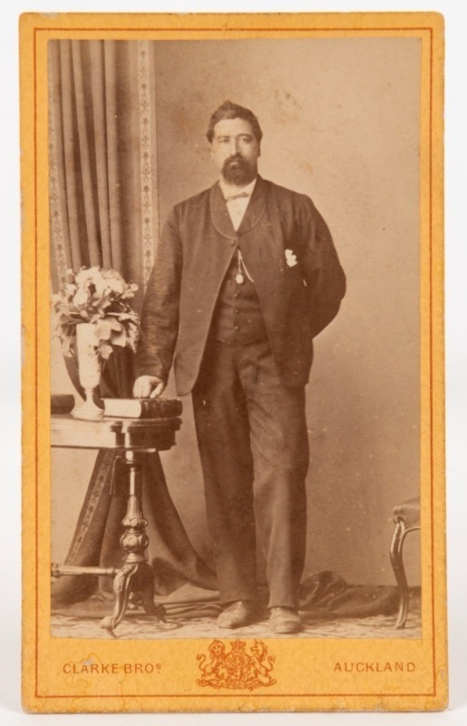 CLARKE BROTHERS, Queen St., AUCKLAND: carte-de-visite bearing an albumen paper photograph of a Maori gentleman, who appears to have been posed with his right hand on a bible, circa 1870s; overall 10 x 6cm. 