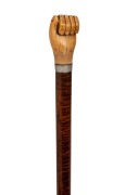 An antique walking stick with carved fist whale's tooth handle, silver collar, on a fiddleback blackwood shaft with metal ferrule,&nbsp;19th century, 93cm high