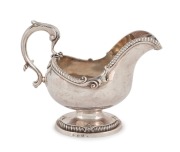 A fine quality Georgian cast sterling silver Rococo sauce boat with engraved griffin crest, maker's marks illegible, made in London, circa 1767, 16cm high, an impressive 556 grams