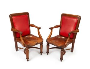 A pair of antique Australian blackwood elbow chairs with carved saddle seats and red leatherette upholstery, 19th century. Almost certainly a government department issue, possibly the Victorian Senate. 94cm high, 62cm wide, 62cm deep