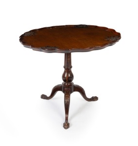 An antique English mahogany pedestal occasional table in the Georgian style, with ornately carved pie crust top and claw feet, 19th/20th century, 70cm high, 84cm wide, 84cm deep
