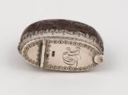 An antique burra nut vesta case carved with a vignette of an Aboriginal hunting an emu, mounted in silver, 19th century, stamped "STG", ​​​​​​​4cm high - 2