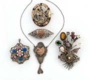 St. George and the dragon silver gilt brooch set with pink stones, a silver and enamel pendant/brooch with cabochon pink and blue stones, a silver filigree brooch and matching necklace adorned with rose gold hearts, and an unusual dress brooch crafted fro