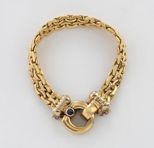 An 18ct yellow gold bracelet with cabochon sapphire clasp, stamped "750", 16cm long, 27.3 grams