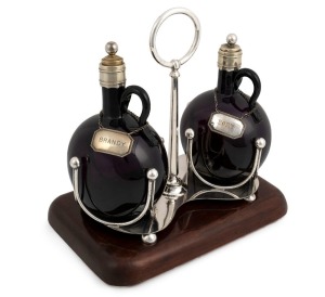 An antique silver plated two bottle decanter set on carved cedar stand with attractive amethyst glass and silver plated port and brandy labels, 19th century, 29cm high