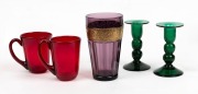 A pair of vintage green glass candlesticks, together with a pair of ruby glass mugs, and an amethyst glass vase with gilt border in the Moser style, 20th century, the largest 16cm high