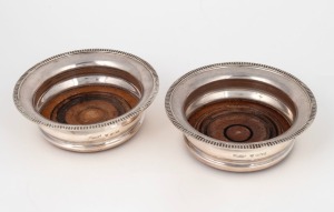 A pair of English sterling silver wine bottle coasters, retailed by Garrard & Co. of London, 5cm high, 16cm diameter