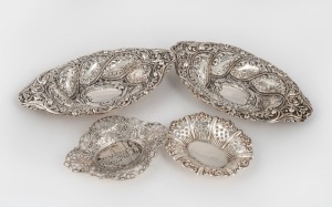 A pair of sterling silver bon-bon dishes with repousse decoration, together with two small pierced silver dishes (four items) the largest 21cm wide, 250 grams total