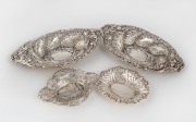 A pair of sterling silver bon-bon dishes with repousse decoration, together with two small pierced silver dishes (four items) the largest 21cm wide, 250 grams total&nbsp;