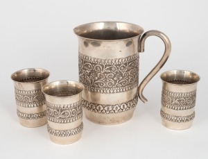 An Eastern silver jug together with three matching silver beakers, 20th century, (4 items), stamped "SILVER", the jug 15.5cm high, 564 grams total