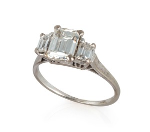 An impressive 18ct white gold ring with 1.3 carat central emerald cut diamond flanked by two emerald cut diamonds, stamped "750"
