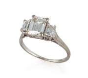 An impressive 18ct white gold ring with 1.3 carat central emerald cut diamond flanked by two emerald cut diamonds, stamped "750"