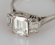 An impressive 18ct white gold ring with 1.3 carat central emerald cut diamond flanked by two emerald cut diamonds, stamped "750" - 2