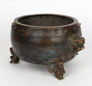 An antique Chinese bronze censer with lion mask handles and figural feet, Qing Dynasty, 19th century, 15cm high, 27cm across the handles