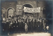 A circa January 1916 silver gelatin photograph (13.5 x 19cm), laid down on backing card (W. Mason & Co. of Bridge Road, Richmond), depicting a group of men in front of the recruiting office under a banner which reads "RICHMOND'S 1st QUOTA of RECRUITS For - 2