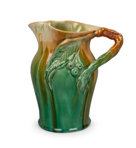 REMUED green glazed pottery jug with orange highlights, adorned with applied gumnuts, leaf and branch handle, incised "Remued, 54LM", 24cm high