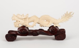 A Chinese carved ivory dragon ornament on wooden stand, early to mid 20th century, ​​​​​​​18cm long