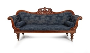 A Colonial Australian cedar double ended settee with ornately carved back and legs, upholstered in later blue leaf pattern fabric, Tasmanian origin, circa 1845, 110cm high, 230cm wide, 65cm deep