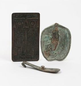 Three Chinese bronze artefacts comprising of&nbsp;a rectangular coinage token, Qing Dynasty; a bronze belt buckle clasp, Han Dynasty and a thin heart shaped bronze mirror, Song Dynasty, the largest 12cm high