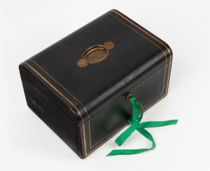 An antique embossed leather travelling box fitted with drop-front, drawers and compartments lined in plum silk and velvet, 19th century, 18cm high, 31cm wide, 23cm deep