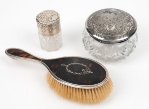A sterling silver topped crystal vanity jar by Henry Matthews of Birmingham, circa 1903; a sterling silver and tortoise shell hand mirror by Edward Souter Barnsley of Birmingham, circa 1920; and an antique American silver plated lidded crystal jar, engraved "Tennis 1912" (3 items)
