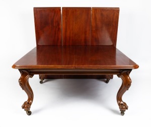 An impressive antique English mahogany three leaf extension dining table with ogee moulded top, carved cabriole legs terminating in ball and claw feet with original substantial brass castors, circa 1865, the table fitted with telescopic extension mechanis