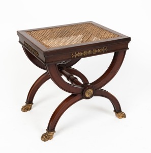 An antique French mahogany boudoir stool in the classical style with cross frame supports and stretcher, rattan top and ormolu mounts, 19th/20th century, 48cm high, 47cm wide, 38cm deep