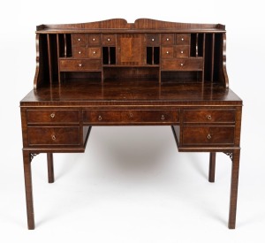 An English Georgian reproduction Carlton House desk with flame mahogany veneered and cross banded edge, circa 1930, the gallery back well fitted with storage drawers and pigeon holes, 123cm high, 128cm wide, 75cm deep