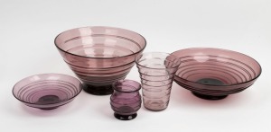 WHITEFRIARS&nbsp;English amethyst&nbsp;and aubergine glass group comprising three footed bowls, a footed vase and a flared vase,&nbsp;all with ribbon trail decoration, mid 20th century, (5 items), the largest bowl 28cm diameter&nbsp;
