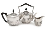 An antique English sterling silver three piece tea service by Goldsmiths & Silversmiths Company of London, circa 1904, the largest piece 22cm high, 1300 grams total including wooden handles1500