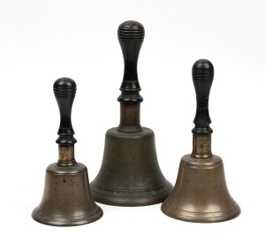 A graduated set of three antique bells with turned ebony handles, 19th century, the largest 26cm high