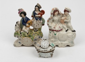STAFFORDSHIRE antique English pottery figural groups with clock displays, together with an antique Continental porcelain trinket box with pocket watch top, 19th century, (3 items), the largest 19cm high