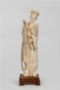 A Chinese carved ivory statue of a lady holding a peony, on later timber stand, early to mid 20th century, 23cm high overall