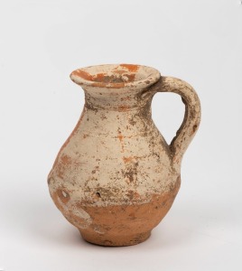 A Roman terracotta jug with remains of cream glaze finish, 1st-2nd century, A.D., 8.5cm high