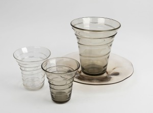 WHITEFRIARS two English smokey grey glass ribbon vases and a table bowl with wave decoration; together with a clear glass vase with ribbon trail decoration, mid 20th century, (4 items), the bowl 31cm diameter