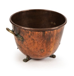 An antique copper cauldron pot with heavy brass handles and claw feet, 19th century, 33cm high, 50cm across the handles