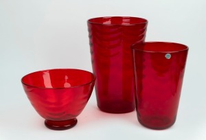 WHITEFRIARS&nbsp;two English ruby red glass tumbler vases designed by Marriott Powell; together with a&nbsp;footed bowl,&nbsp;all with wave ribbed pattern decoration, mid 20th century, (3 items) one bearing original blue foil export label, the largest 31cm high