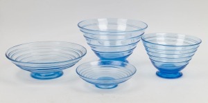 WHITEFRIARS&nbsp;four English sapphire blue&nbsp;glass footed bowls with ribbon trail decoration, mid 20th century, the smallest example with original Whitefriars export blue foil label, the largest 28cm diameter