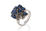 A vintage 18ct white gold designer cocktail ring, adorned with blue sapphires and white diamonds, stamped "18ct", 8.2 grams total
