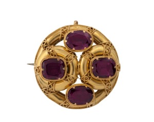 An antique Australian 18ct gold circular brooch, set with four purple stone, 19th century, 3.2cm wide, 9.2 grams total